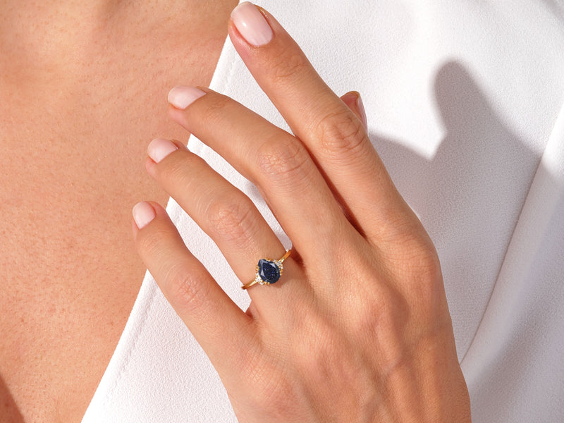 Pear Blue Sandstone Engagement Ring with Round Moissanite Sidestones.