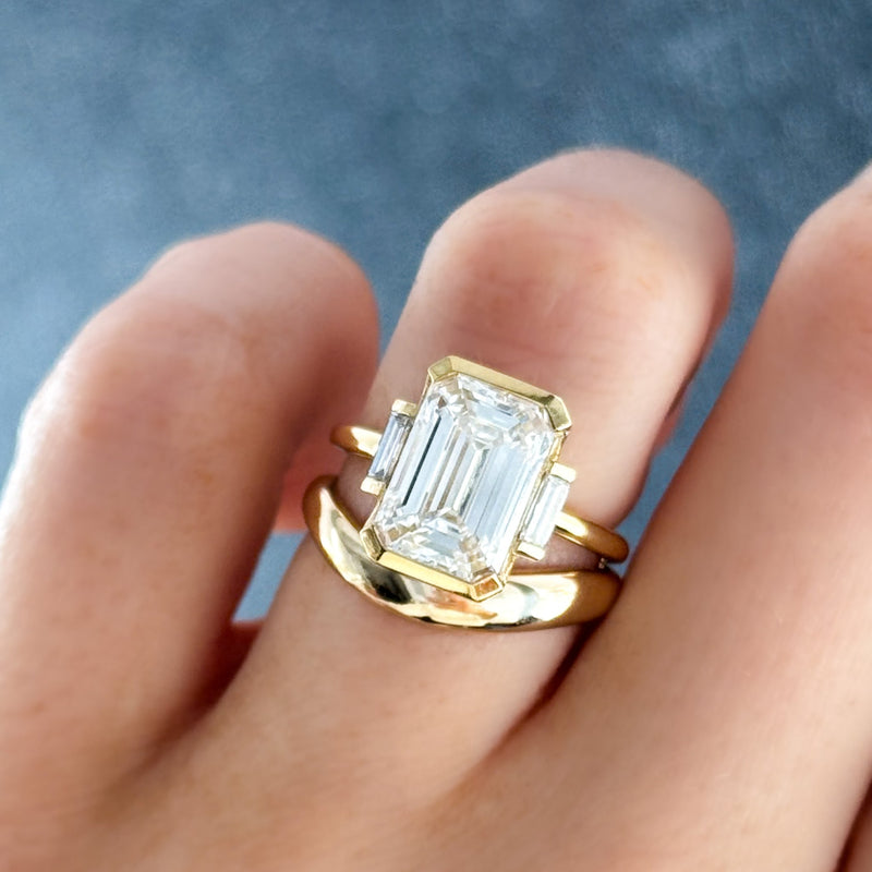 Modern Minimalism: Emerald Cut Half Bezel Ring with Baguettes