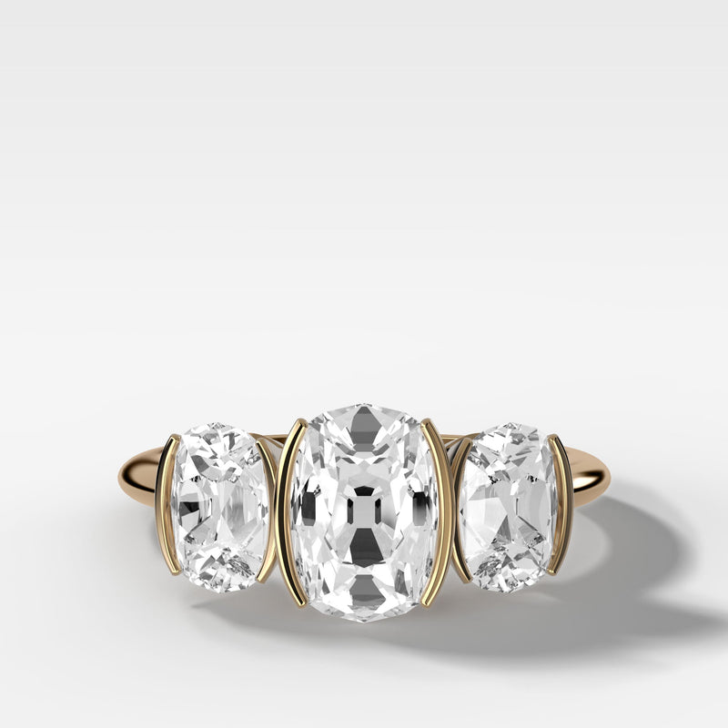 elongated-old-mine-cut-three-stone-ring-half-bezel